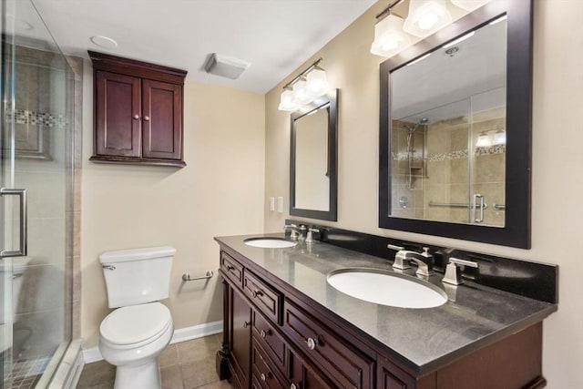 bathroom featuring tile patterned floors, vanity, toilet, and a shower with door