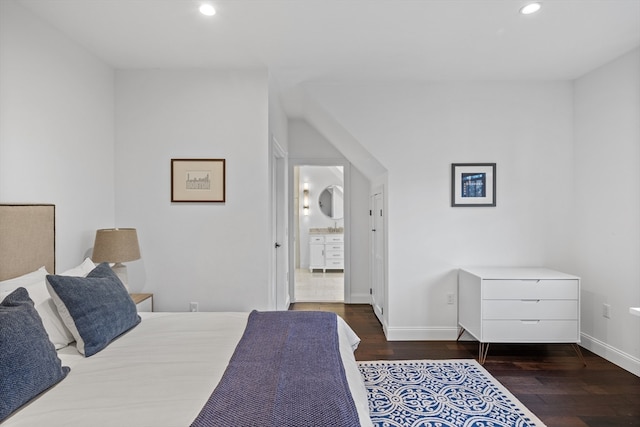 bedroom featuring dark hardwood / wood-style flooring and connected bathroom