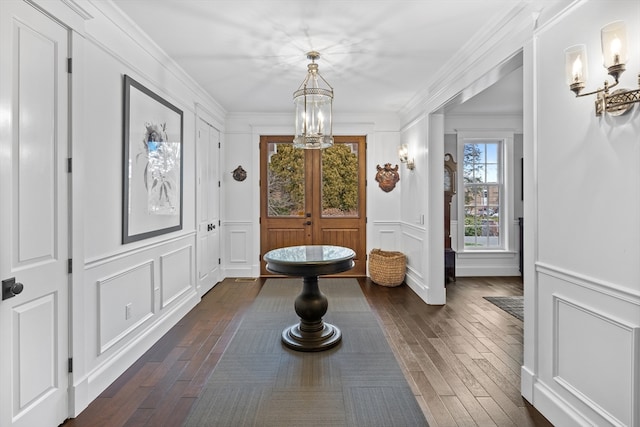 corridor featuring dark hardwood / wood-style flooring, an inviting chandelier, and ornamental molding