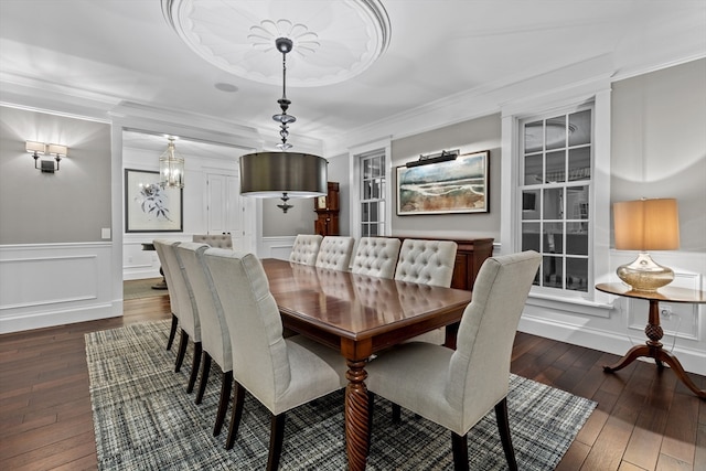 dining area featuring an inviting chandelier, ornamental molding, and dark hardwood / wood-style floors