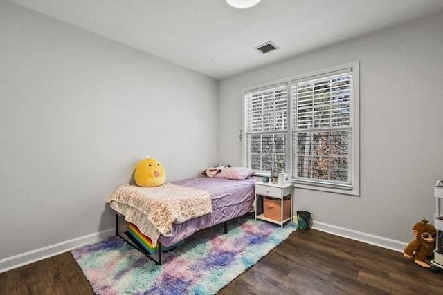 bedroom with dark hardwood / wood-style floors