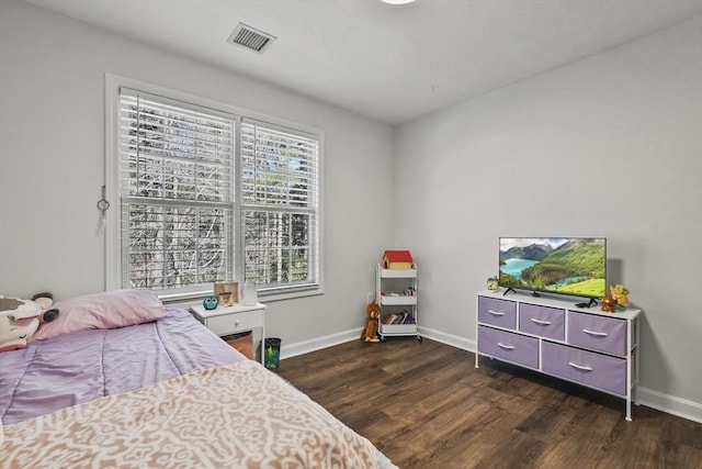 bedroom featuring multiple windows and dark hardwood / wood-style floors