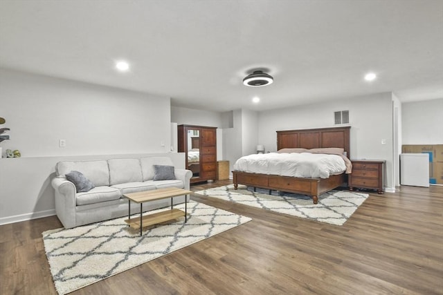 bedroom featuring dark hardwood / wood-style flooring and refrigerator