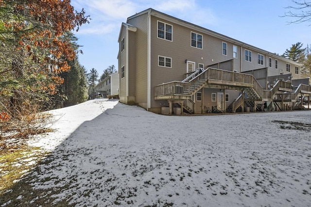 snow covered property with a deck