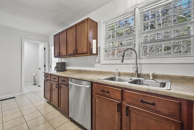 kitchen with dishwasher, sink, and light tile patterned floors