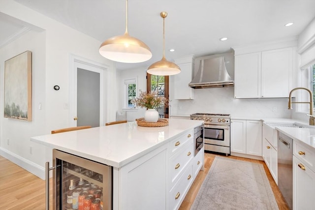 7 Newman St, Cambridge, MA 02140 - kitchen featuring wall chimney exhaust hood, stainless steel appliances, wine cooler, a sink, and light wood-style flooring
