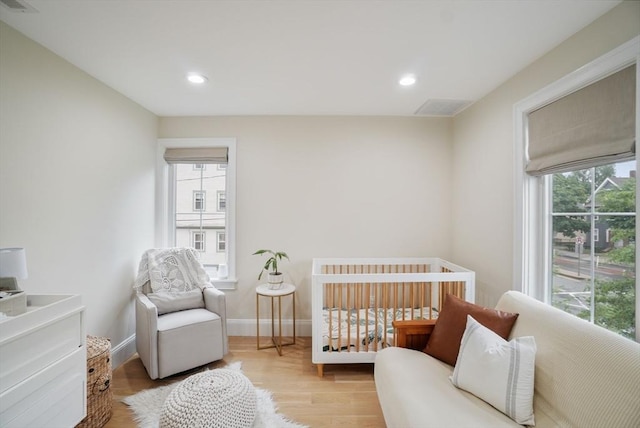 7 Newman St, Cambridge, MA 02140 - bedroom with multiple windows, wood finished floors, recessed lighting, baseboards, and a crib