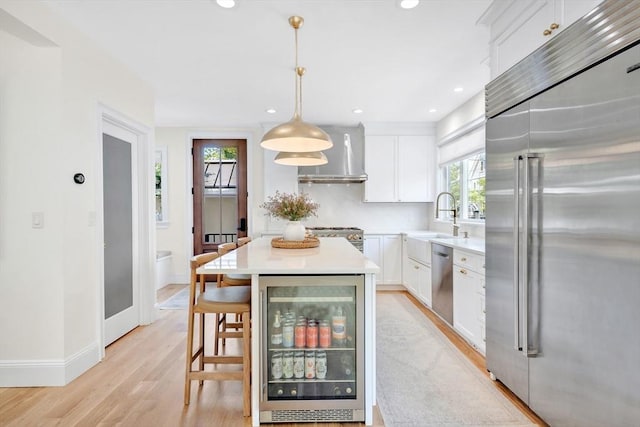 7 Newman St, Cambridge, MA 02140 - kitchen featuring stainless steel appliances, wall chimney range hood, beverage cooler, healthy amount of natural light, and recessed lighting
