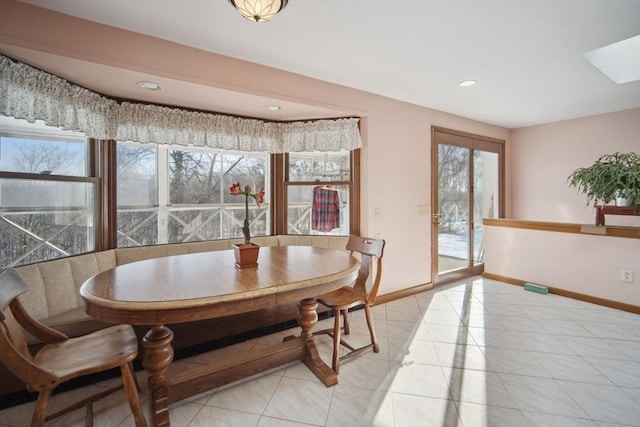 tiled dining area with a skylight