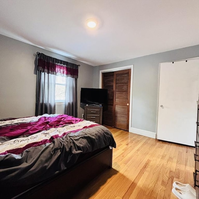 bedroom featuring baseboards, a closet, and light wood-style flooring