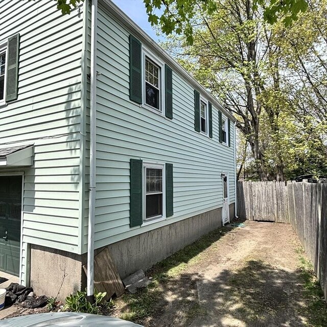 view of side of property with a garage and fence