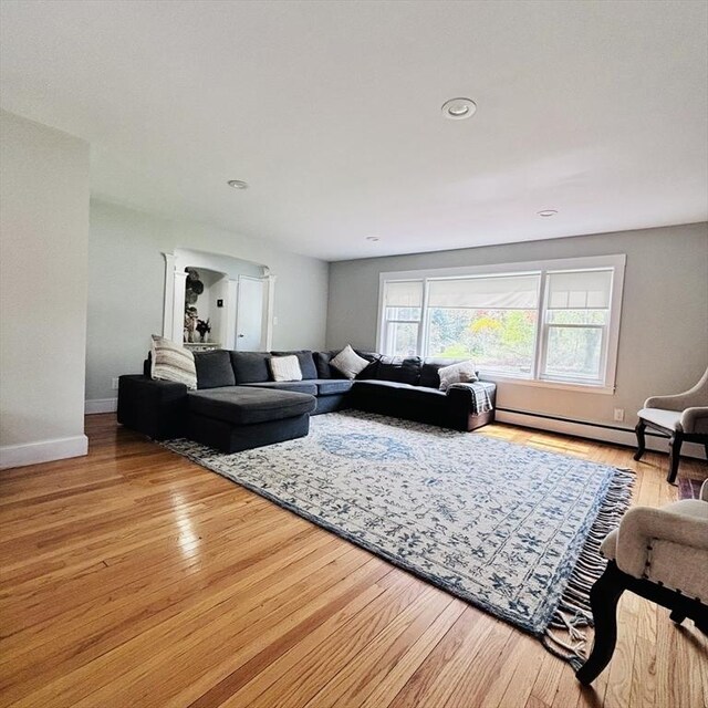 living area with baseboards, recessed lighting, a baseboard heating unit, and wood finished floors
