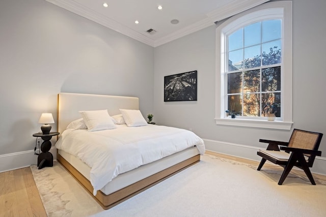 bedroom with light hardwood / wood-style floors and crown molding