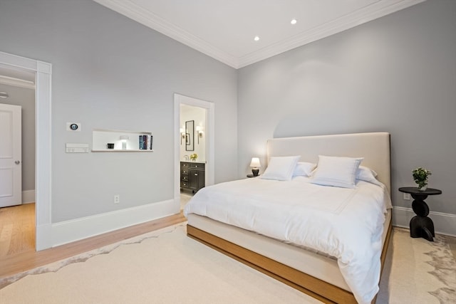 bedroom with ensuite bath, ornamental molding, and light wood-type flooring