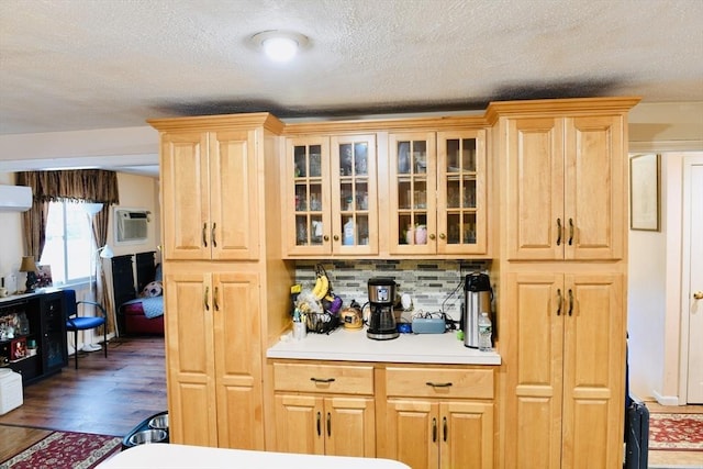 kitchen with tasteful backsplash, dark wood-type flooring, light brown cabinets, and a wall unit AC