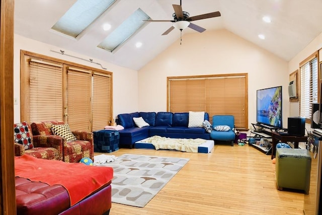 living room with hardwood / wood-style flooring, ceiling fan, and high vaulted ceiling