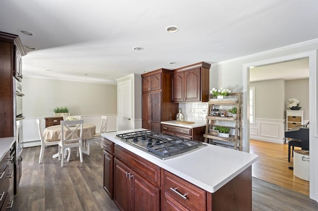 kitchen featuring light countertops, crown molding, stainless steel gas cooktop, and wainscoting