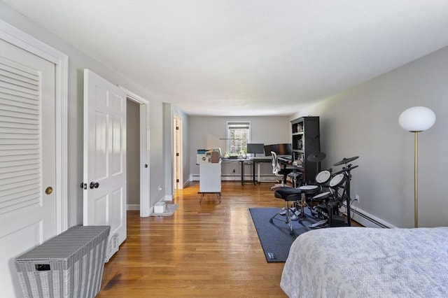bedroom with a baseboard radiator and wood finished floors