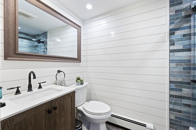 bathroom with vanity, toilet, tiled shower, and a baseboard radiator