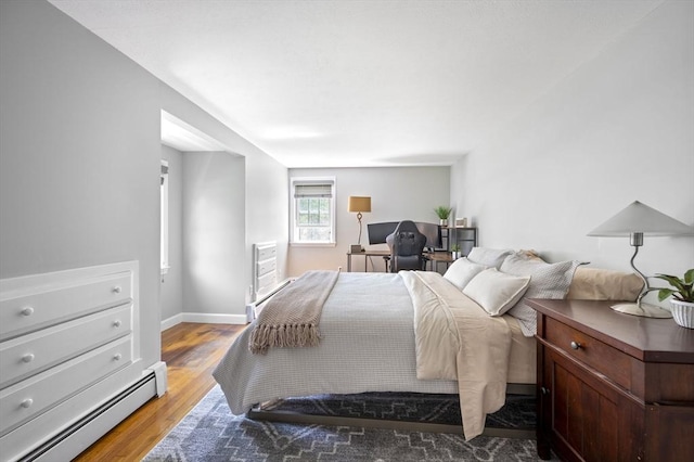 bedroom featuring baseboards, a baseboard radiator, and wood finished floors