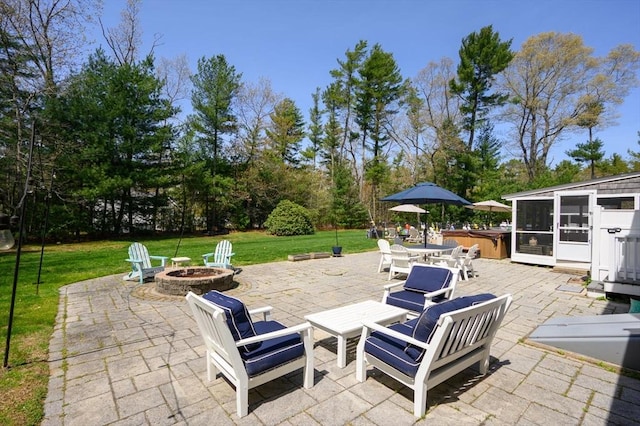 view of patio / terrace featuring a hot tub and a fire pit