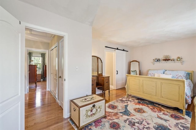45 Washington St Unit B7, Methuen, MA 01844 - bedroom featuring a barn door, light wood finished floors, baseboards, and attic access