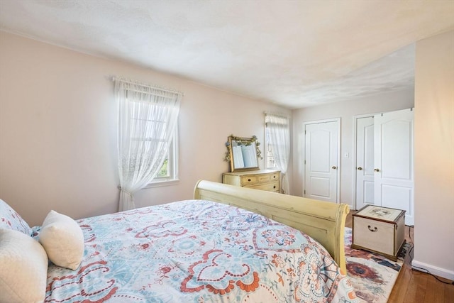 45 Washington St Unit B7, Methuen, MA 01844 - bedroom featuring multiple windows, wood finished floors, multiple closets, and baseboards
