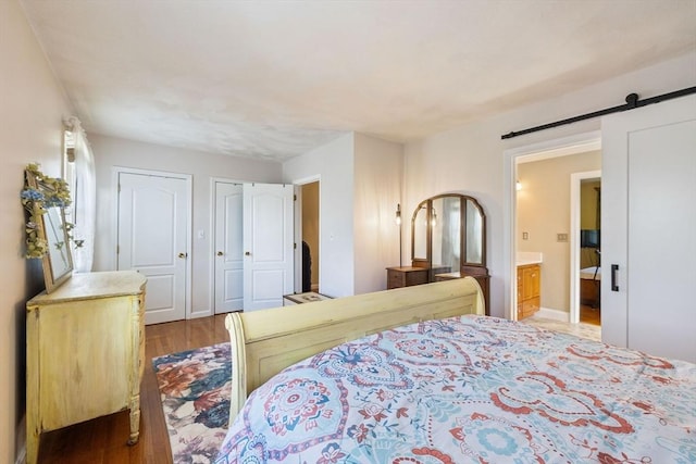 45 Washington St Unit B7, Methuen, MA 01844 - bedroom with wood finished floors, two closets, a barn door, and ensuite bath