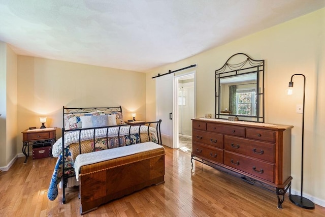 45 Washington St Unit B7, Methuen, MA 01844 - bedroom with a barn door, wood finished floors, and baseboards