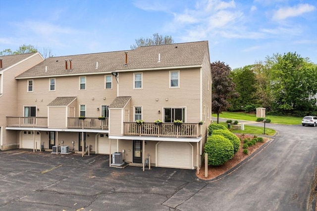 45 Washington St Unit B7, Methuen, MA 01844 - rear view of property with an attached garage, central AC unit, driveway, and roof with shingles