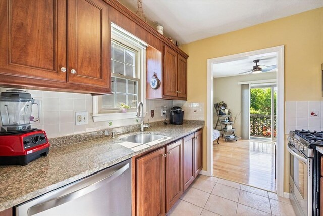 45 Washington St Unit B7, Methuen, MA 01844 - kitchen featuring appliances with stainless steel finishes, a sink, tasteful backsplash, light tile patterned floors, and stone counters