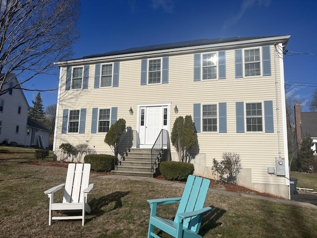 colonial home with a front lawn