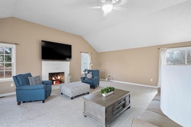 carpeted living room with ceiling fan, a wealth of natural light, and vaulted ceiling