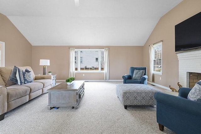 carpeted living room with a wealth of natural light, a fireplace, and lofted ceiling