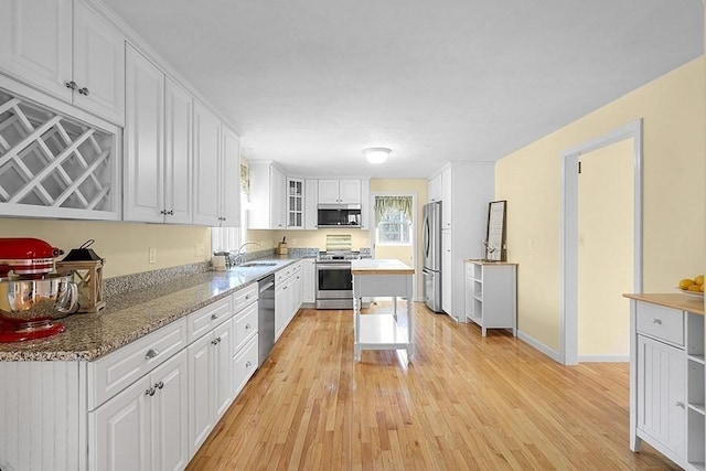 kitchen with sink, white cabinetry, stainless steel appliances, and light wood-type flooring