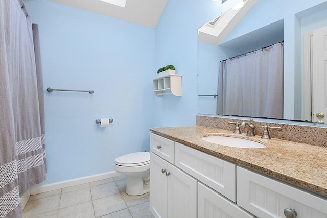 bathroom with tile patterned floors, vanity, toilet, and vaulted ceiling with skylight