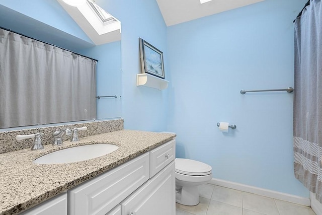 bathroom with tile patterned flooring, vanity, toilet, and lofted ceiling with skylight