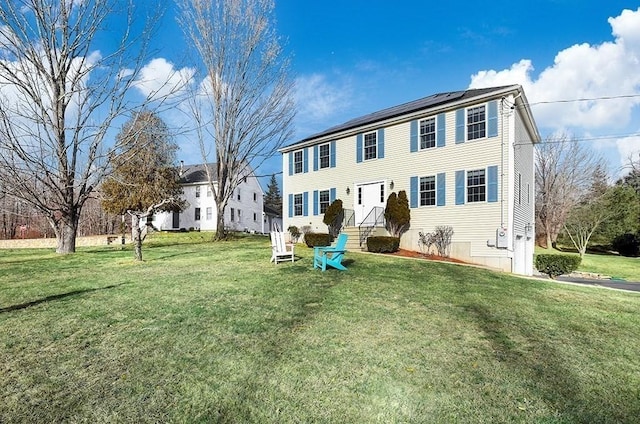 view of front of house featuring a front yard and solar panels