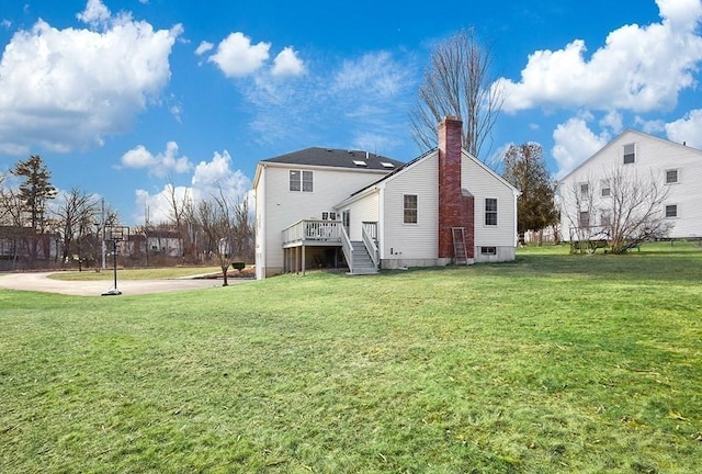 back of property with a lawn and a deck