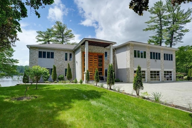 290 Massapoag Rd, Tyngsborough, MA 01879 - modern home with stone siding, a front yard, and stucco siding