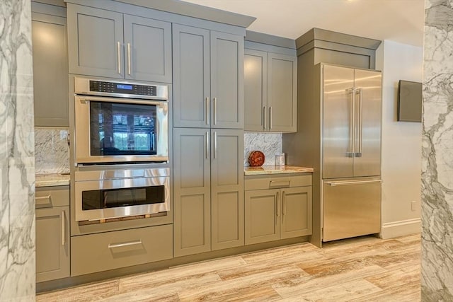 290 Massapoag Rd, Tyngsborough, MA 01879 - kitchen featuring appliances with stainless steel finishes, gray cabinetry, backsplash, and light wood-style floors