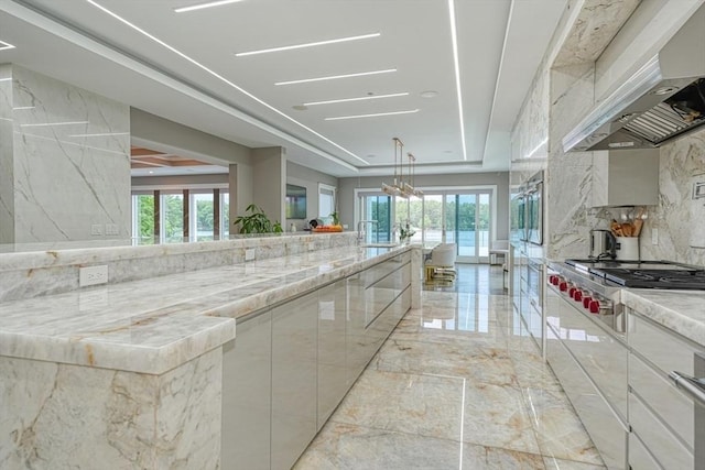 290 Massapoag Rd, Tyngsborough, MA 01879 - kitchen featuring light marble finish flooring, wall chimney range hood, stainless steel gas cooktop, and healthy amount of natural light