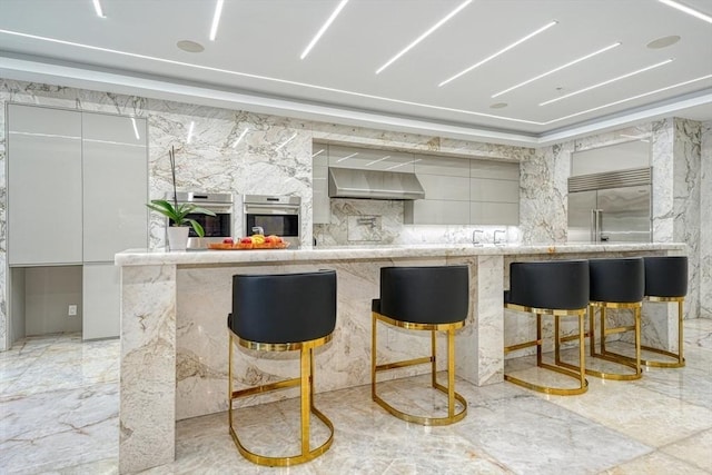 290 Massapoag Rd, Tyngsborough, MA 01879 - bar with stainless steel appliances, light marble finish flooring, and wall chimney exhaust hood