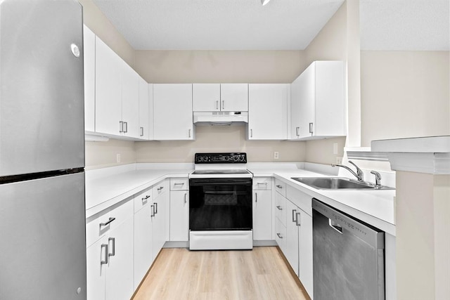 kitchen featuring a sink, light wood finished floors, light countertops, stainless steel appliances, and under cabinet range hood