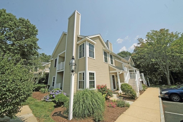 view of side of property with a chimney and stairs