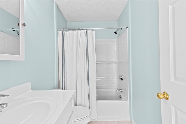 bathroom with vanity, shower / bath combo, toilet, and a textured ceiling