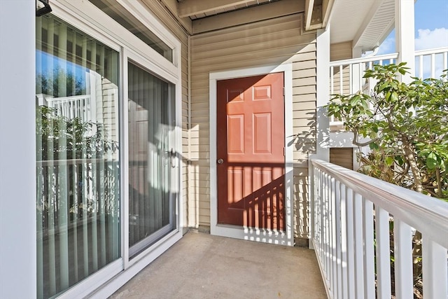 view of exterior entry with a balcony