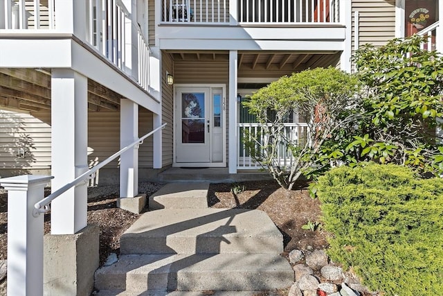 property entrance featuring a porch and a balcony