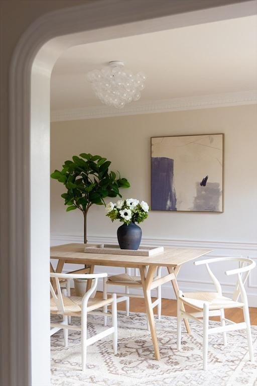 dining area with arched walkways and ornamental molding