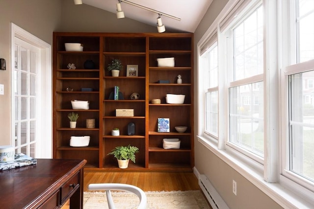 office featuring rail lighting, a baseboard radiator, lofted ceiling, and wood finished floors